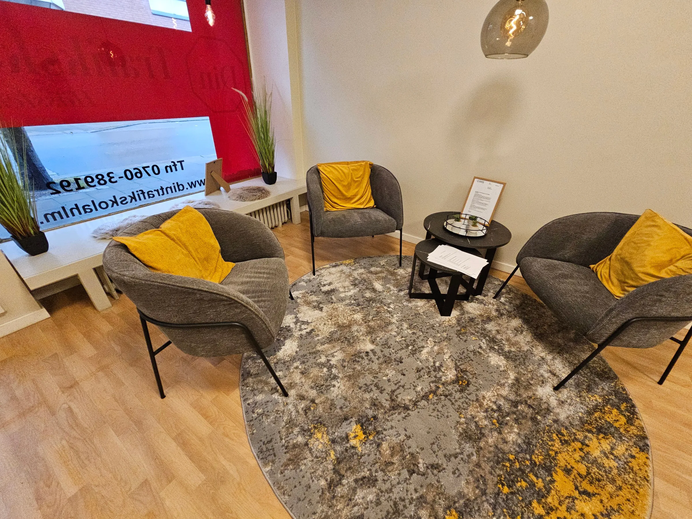 Bekvämt väntområde med moderna fåtöljer och gula accentkuddar
